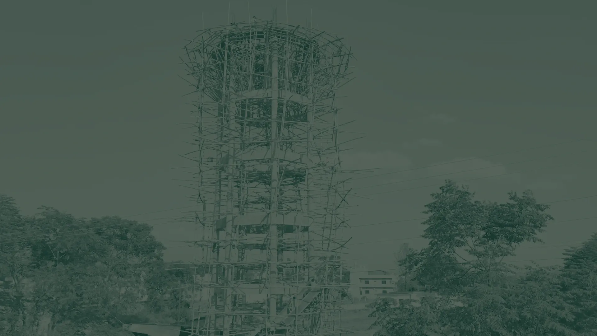 Elevated water tank under bamboo scaffolding at a construction site